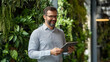 © EmmaStock - CEO in an innovative green office, holding a tablet, with indoor vertical gardens and energy-efficient lighting
