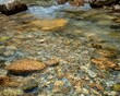 © Jari.art - Clear Stream Water Flowing Over Sunlit Rocks