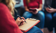 © Jaruwan photo - A mediator writing on notepad while listening to negotiation participants. scene captures focused and professional atmosphere during mediation session