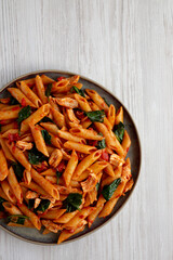 Wall Mural - Homemade One-Pot Spinach And Tomato Pasta on a Plate, top view. Copy space.