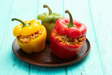 Wall Mural - Baked stuffed pepper ( paprika ) with rice , carrot and meat . Top view on rustic background