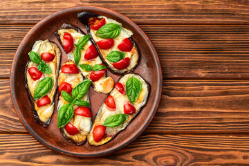 Wall Mural - Italian mini pizza . Aubergine (eggplant ) with mozzarella cheese and basil . On rustic background