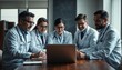 © Ruslan Gilmanshin - Doctors sit around a table, looking at a laptop computer