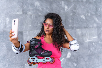 Sensual woman taking selfie holding inline skates on urban park