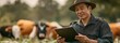 © tongpatong - A worker on a livestock farm, dressed in uniform, is an Asian farmer using a digital tablet.