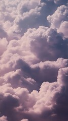 Wall Mural - A breathtaking view of fluffy white clouds against a soft purple sky.