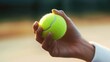 © twinklewin labs - Hand holding a tennis ball