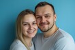 © Mark G - A studio close-up portrait of a young white couple wearing casual t-shirts, with a colourful background.