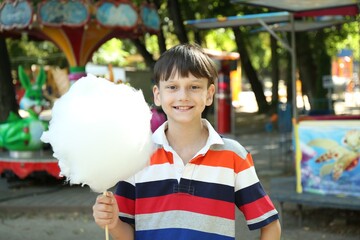 Poster - Portrait of little boy with sweet cotton candy in park