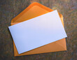 © Giedrius - An orange envelope with a white piece of paper on it