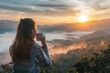 © Patcharaphon - Woman drinking coffee and looking at sunrise amidst the beautiful scenery. Travel, relax concept