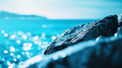 Wall Mural -  A tight shot of a rock on the water's edge, surrounded by a blue sky behind