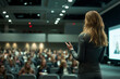 © Chebix - A woman stands in front of a large audience, giving a presentation