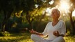 © sunchai - An elderly woman meditating peacefully outdoors, surrounded by nature's tranquility and warm sunlight, embodying serenity and mindfulness.