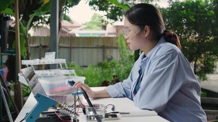 Asian woman programming microcontroller to control Analog Dissolved Oxygen Sensor to find the appropriate value of oxygen in water for use in agriculture in aquaculture. Internet of Thing  (IoT)