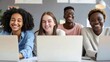 © Ruby Stock - Young creative group four multicultural happy students working on project sitting at desk together in classroom office using laptops computers with blank empty mockup screen for ads