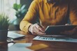 © Aditya - Man in casual attire working on a tablet in a cozy home office, relaxed and productive environment, natural light