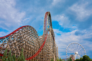 Roller coaster attraction in amusement park. Entertainment at summer holiday