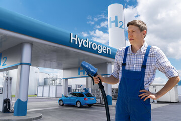 Sticker - Man holds a hydrogen fueling nozzle. Refueling car with hydrogen fuel.