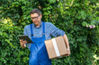 © scharfsinn86 - Delivery man in uniform with digital tablet.