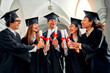 © HBS - Happy graduates of a college or university sincerely rejoice at graduation. Five friends are holding diplomas with red ribbons and talking.