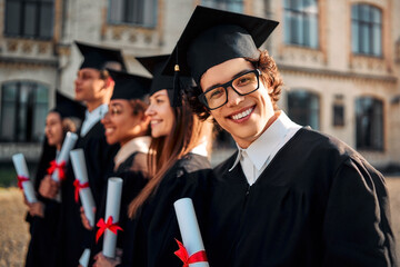  Cheerful handsome happy graduate smiling and looking at camera. Achievement, motivation and belief in a bright future.