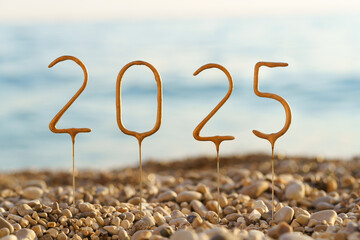 Close-up of golden numbers 2025 year in pebbles on background of sea water and sunset on the beach. Happy New Year, wishes for success and prosperity, congratulations, celebration, greeting card 