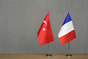 Table flags of France and Turkey on a gray blurred background