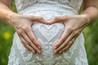 © JERRYsnipe.AI - Closeup of a mother s hands forming a heart over her belly, representing love and deep emotional connection with her baby, Love and bond, emotional journey