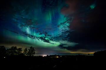 Wall Mural - northern lights dancing over the sky sky in the country road