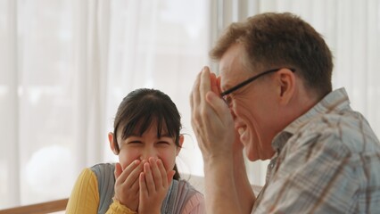 Grandfather and granddaughter together talking about entertainment media on TV. Old senior use conversation communicate with young generation cross generation gap strengthen family bond. Divergence.