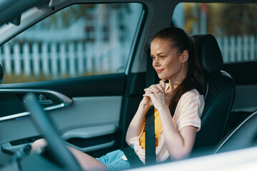 woman in a car, smiling, casual attire, interior, happy expression, focused on the road, modern vehicle backdrop, relaxed atmosphere, summer vibes, bright daylight