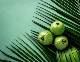 Wall Mural - Ripe and juicy sweet Guava fruits. Ripe food on the background of stacked palm leaves summer concept