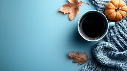 Wall Mural -   A cup of coffee rests on a blue surface amidst autumn leaves and a knitted sweater against a blue backdrop