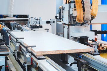 Poster - A woodworking shop with a large machine cutting a piece of wood. The machine is surrounded by a lot of dust and debris