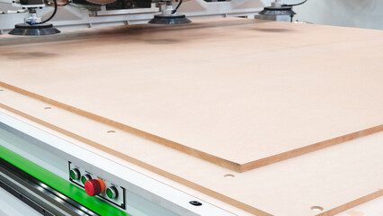 Poster - A woodworking shop with a large machine cutting a piece of wood. The machine is surrounded by a lot of dust and debris