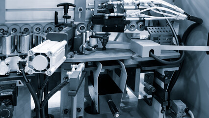 Poster - A machine is cutting a strip of wood. The machine is surrounded by other machines