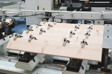 Wall Mural - A wooden board is being cut into pieces by a machine