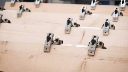 Poster - A wooden board is being cut into pieces by a machine