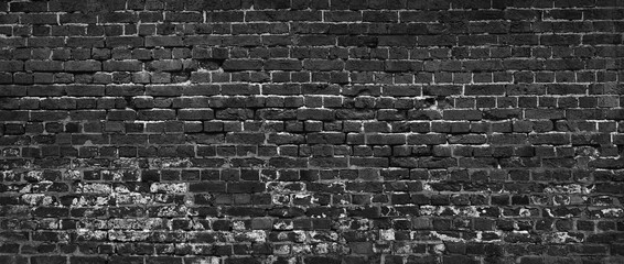 Leinwandbilder - A brick wall with a black color. The wall is made of bricks and has a rough textur