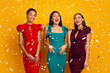 © Prostock-studio - Three Excited Diverse Women Standing Under Falling Confetti Having Party Over Yellow Studio Background. Panorama