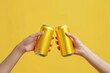 © itchaznong - Two people are holding up two cans of beer, one of which is gold