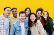 © Xavier Lorenzo - Group portrait of young multiethnic student friends against yellow wall - Diverse united millennial boys and girls standing outside. International youth community people concept