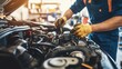 © Chonticha - A mechanic working on a car engine in a well-equipped auto repair shop.