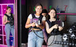 © JackF - Two cheerful and happy girls friends pose in locker room before laser tag match. Modern entertainment, hobby, tactical outdoor game