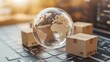 © atipong - International freight or shipping service for online shopping or ecommerce concept : Paper boxes or carton put in circle around a clear crystal globe with world map on a computer notebook keyboard.