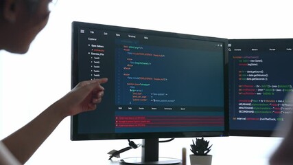 Slow motion back end software developer engineer for computer programming working together on debugging writing computing code, solving complex algorithms display on monitor in office. Burgeoning