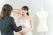 © buritora - 式場・ドレスショップでドレスを選ぶ新婦・花嫁とプランナーの女性
