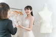 © buritora - 式場・ドレスショップでドレスを選ぶ新婦・花嫁とプランナーの女性