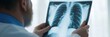 © gunzexx png and bg - A doctor carefully examines a chest X-ray, focusing on the detailed image to diagnose the patient's health condition, demonstrating a keen attention to medical analysis.